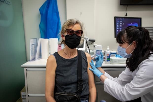 Carolyn Livingston, 64, gets her second dose of the AstraZeneca-Oxford COVID-19 vaccine at a midtown Toronto pharmacy on May 26.