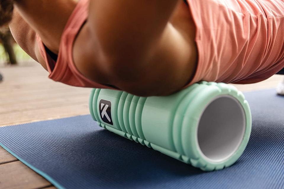 Girl stretching out with blue foam roller.