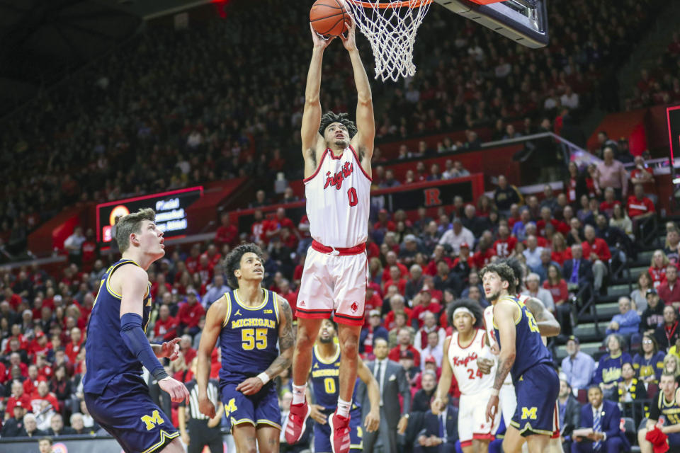 Michigan center Jon Teske, left, and guard Eli Brooks (55) watch as Rutgers guard Geo Baker (0) dunks the ball during the first half of an NCAA college basketball game, Wednesday, Feb. 19, 2020 in Piscataway, N.J. (Andrew Mills/NJ Advance Media via AP)