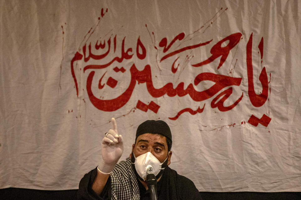 Zakir Tasaduk Hussain, a Kashmiri Shiite elegy reciter, speaks during a ceremony to commemorate Muharram inside a residential house in the interiors of Dal Lake in Srinagar, Indian controlled Kashmir, Sunday, Aug. 23, 2020. Observing the Muslim month of Muharram, which marks the martyrdom of the Prophet Muhammad’s grandson in the battle of Karbala, is an article of faith. But as the coronavirus spreads in Indian-controlled Kashmir, Shiite Muslims prefer to commemorate the holy days inside their home following the advice of religious scholars and health experts in the disputed region’s main city. The banner behind him reads: "Oh Hossein." (AP Photo/Dar Yasin)