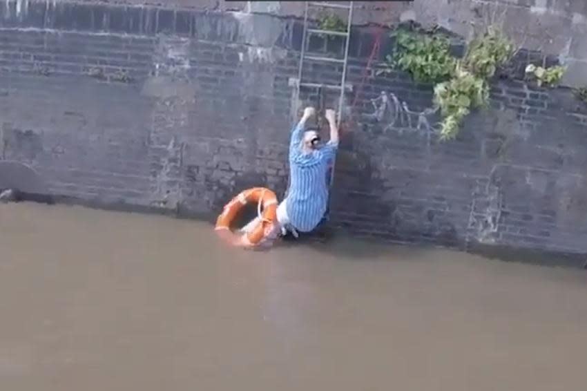 A video still of the woman clinging to a ladder in the Thames after she attempted to save her dog (RNLI)