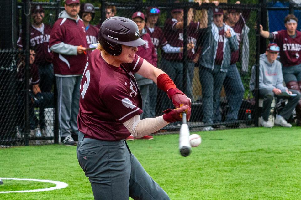 Bishop Stang's Seamus Keller drives the ball to left field.
