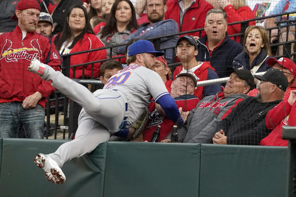 New York Mets first baseman Pete Alonso falls against netting as he catches a foul ball by St. Louis Cardinals' Paul Goldschmidt for an out during the first inning of a baseball game Monday, April 25, 2022, in St. Louis. (AP Photo/Jeff Roberson)