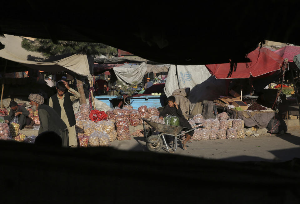 An Afghan boy sits on a wheelbarrow as he waits to sell vegetables at a market in Kabul, Afghanistan, Tuesday, Aug. 6, 2019. (AP Photo/Rafiq Maqbool)