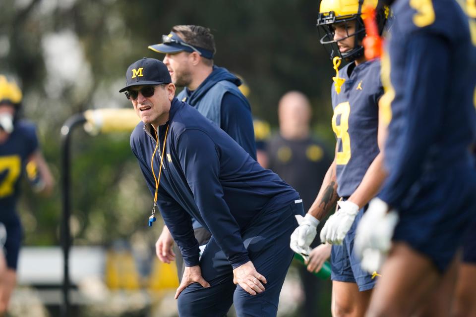 Michigan head coach Jim Harbaugh, left, watches during practice on Friday, Dec. 29, 2023, in Carson, California.
