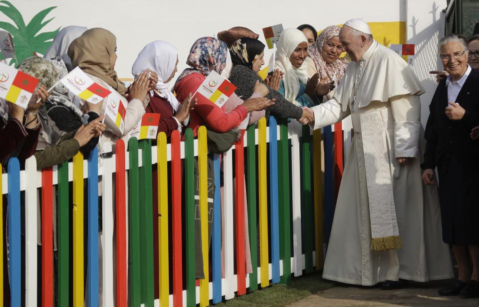 Pope Francis greets some women as he arrives to the Rural Center for Social Services at Temara, south of Rabat, Morocco, Sunday, March 31, 2019. Pope Francis is in Morocco for a two-day trip aimed at highlighting the North African nation's Christian-Muslim ties, while also showing solidarity with migrants at Europe's door and tending to a tiny Catholic flock. (AP Photo/Gregorio Borgia)