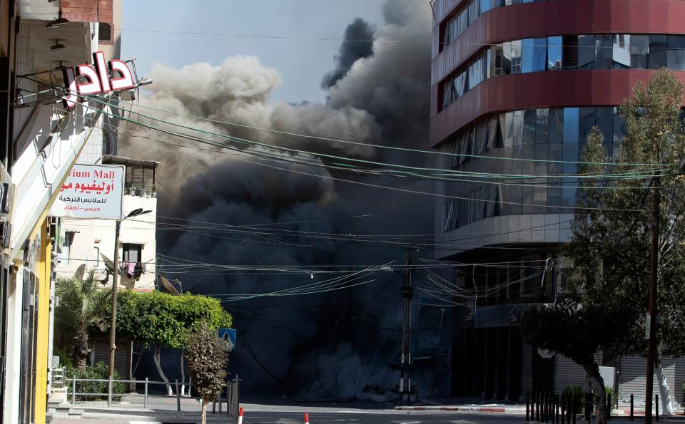 An Israeli airstrike hits the high-rise building that houses The Associated Press' offices in Gaza City, Saturday, May 15, 2021. The airstrike Saturday came roughly an hour after the Israeli military ordered people to evacuate the building. There was no immediate explanation for why the building was targeted. The building housed The Associated Press, Al-Jazeera and a number of offices and apartment.