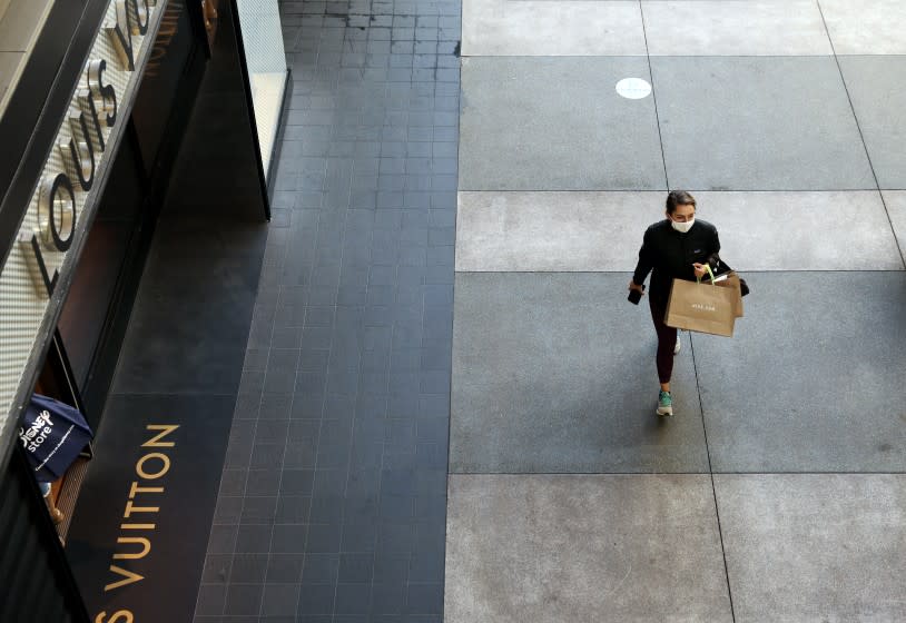 SANTA MONICA-CA-NOVEMBER 13 2020: A lone shopper passes by the Louis Vuitton store at Santa Monica Place on Friday, November 13, 2020. (Christina House / Los Angeles Times)