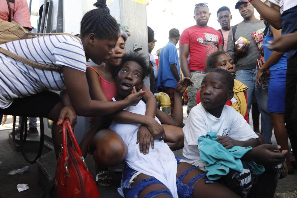 The relative of a person found dead in the street reacts after an overnight shooting in the Petion Ville neighborhood of Port-au-Prince, Haiti, Monday, March 18, 2024. (AP Photo/Odelyn Joseph)