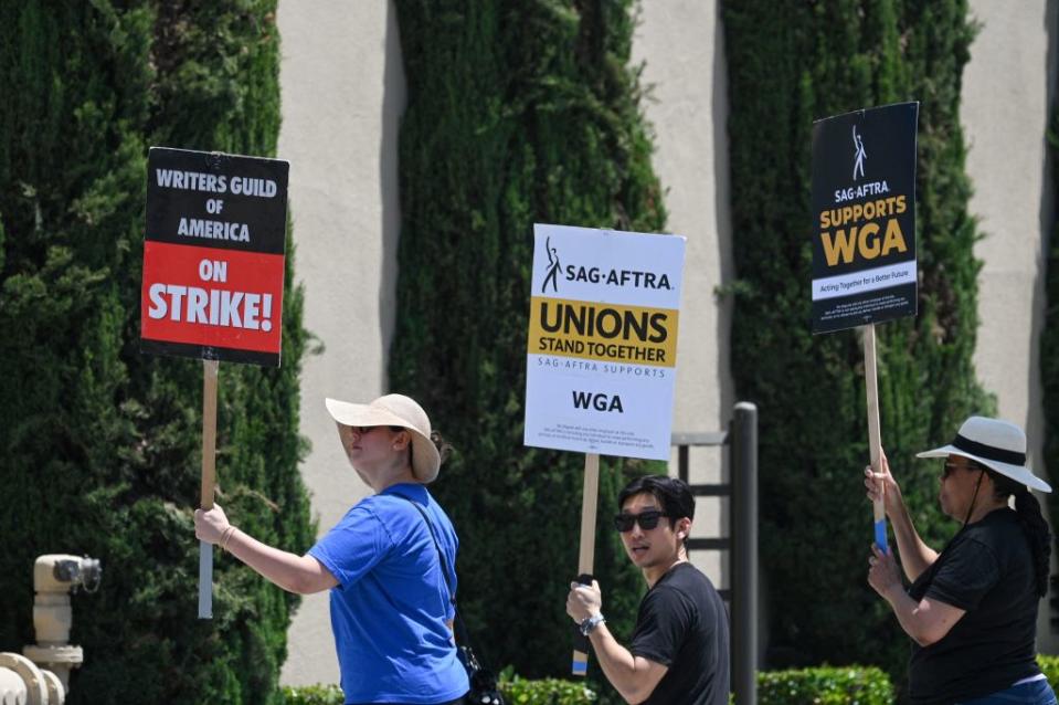 Hollywood writers and their supporters from the SAG AFTRA actors’ union walk the picket line outside Warner Bros Studios in Burbank, California, June 30, 2023. Hollywood’s summer of discontent could dramatically escalate this weekend, with actors ready to join writers in a massive “double strike” that would bring nearly all US film and television productions to a halt. The Screen Actors Guild (SAG-AFTRA) is locked in last-minute negotiations with the likes of Netflix and Disney, with the deadline fast approaching at midnight Friday (0700 GMT Saturday). (Photo by Robyn Beck / AFP) (Photo by ROBYN BECK/AFP via Getty Images)