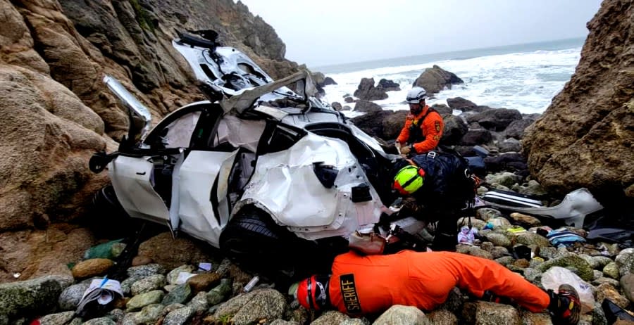 The Patel family’s mangled Tesla is searched at the crash scene below Devil’s Slide in San Mateo County on January 2, 2023. The victims were airlifted in helicopters. (Image courtesy SMCSO)