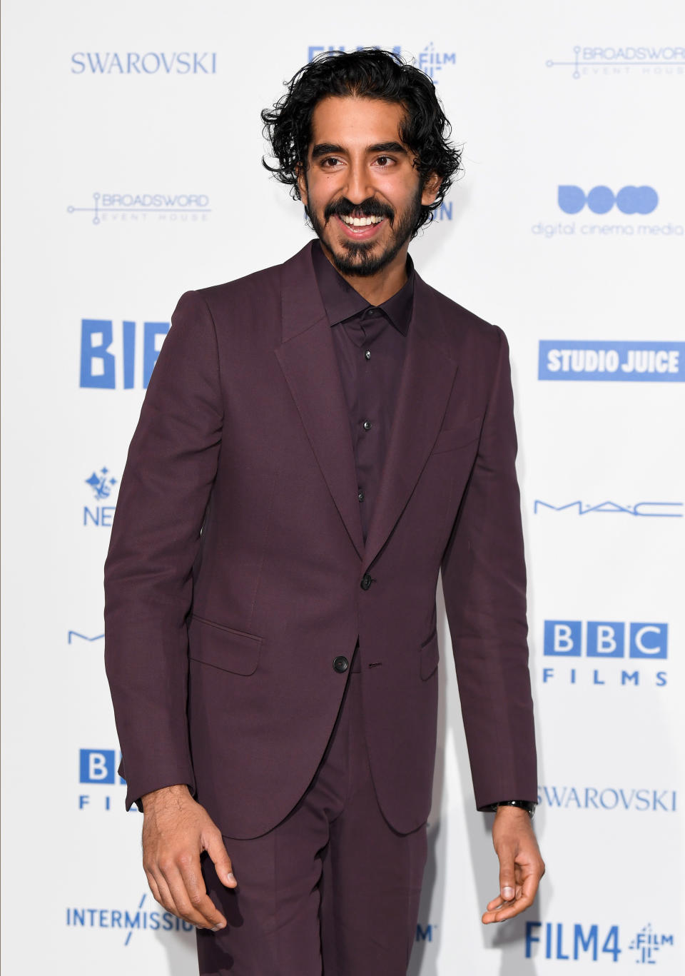 Patel at an event wearing a suit and long hair