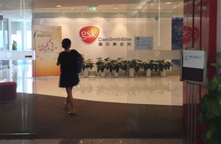 A Chinese employee walks into a GlaxoSmithKline (GSK) office in Beijing, in this July 19, 2013 file photo. REUTERS/Jason Lee/Files