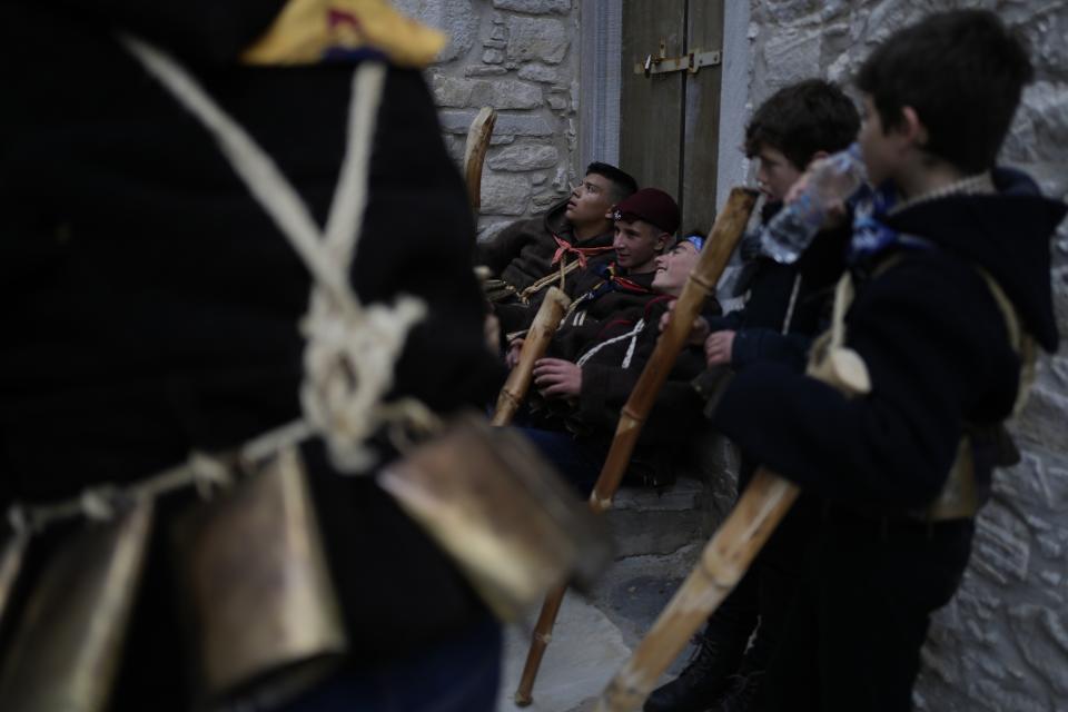 Young bell ringers (Koudounatoi) take a break during a traditional custom, in the village of Apeiranthos, on the Aegean Sea island of Naxos, Greece, on Sunday, Feb. 26, 2023. The first proper celebration of the Carnival after four years of COVID restrictions, has attracted throngs of revellers, Greek and foreign, with the young especially showing up in large numbers. (AP Photo/Thanassis Stavrakis)