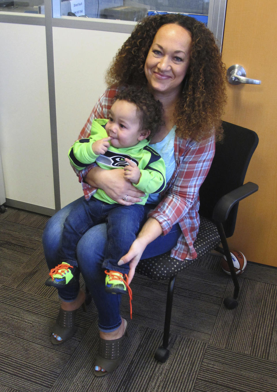 In this March 20, 2017 photo, Rachel Dolezal poses for a photo with her son, Langston in the bureau of the Associated Press in Spokane, Wash. Dolezal, who has legally changed her name to Nkechi Amare Diallo, rose to prominence as a black civil rights leader, but then lost her job when her parents exposed her as being white and is now struggling to make a living. (AP Photo/Nicholas K. Geranios)