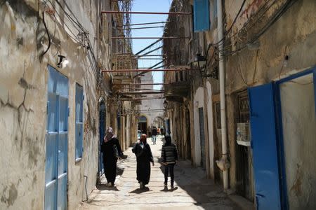 Libyan people walk at the old city of Tripoli, Libya April 13,2019. Picture taken April 13, 2019. REUTERS/Ahmed Jadallah