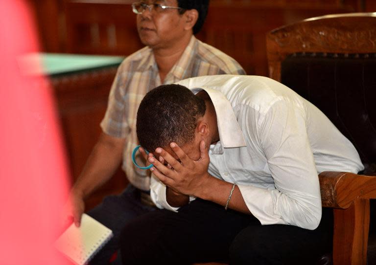 Tommy Schaefer of the US (R) buries his head as he listens to the verdict in his murder trial in a court in Denpasar on Indonesia's resort island of Bali on April 21, 2015