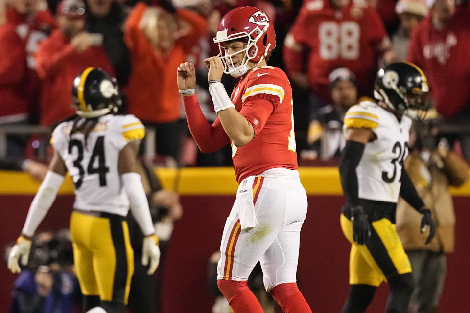 Kansas City Chiefs quarterback Patrick Mahomes, center, celebrates after throwing a touchdown pass as Pittsburgh Steelers safety Terrell Edmunds (34) and free safety Minkah Fitzpatrick (39) walk in the background during the second half of an NFL football game Sunday, Dec. 26, 2021, in Kansas City, Mo. (AP Photo/Charlie Riedel)