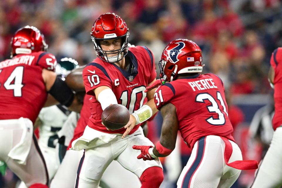 Week 9: Houston Texans quarterback Davis Mills (10) hands the ball off to running back Dameon Pierce as the Texans wore red helmets for the first time during a "Thursday Night Football" game against the Philadelphia Eagles at NRG Stadium.