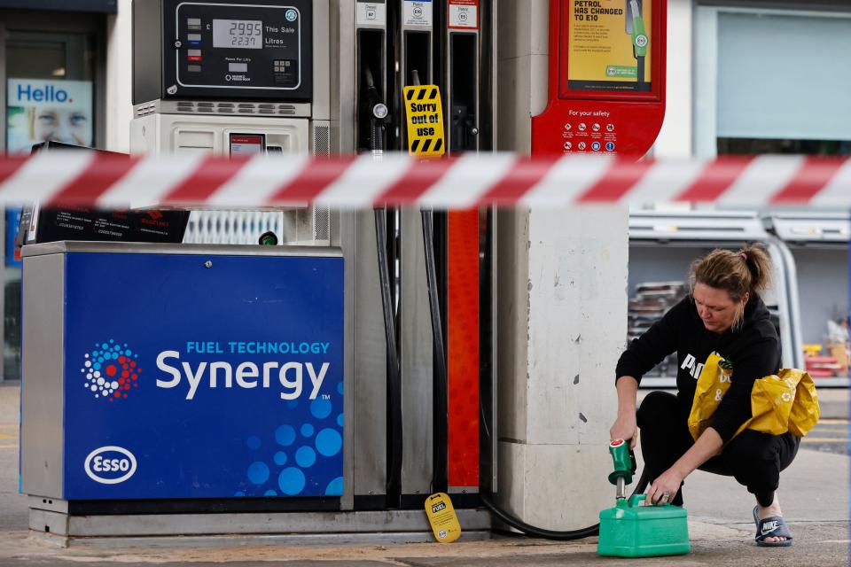 A customer fills a fuel container at a fuel filling station in Leyton, east London