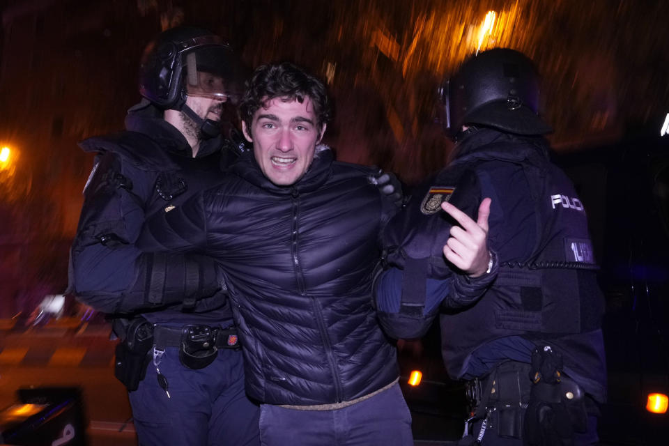 A demonstrator is detained by police during clashes after a protest against the amnesty at the headquarters of Socialist party in Madrid, Spain, Thursday, Nov. 16, 2023. Spain's acting Socialist prime minister, Pedro Sánchez, has been chosen by a majority of legislators to form a new leftist coalition government in a parliamentary vote. The vote came after nearly two days of debate among party leaders that centered almost entirely on a highly controversial amnesty deal for Catalonia's separatists that Sánchez agreed to in return for vital support to get elected prime minister again. (AP Photo/Manu Fernandez)