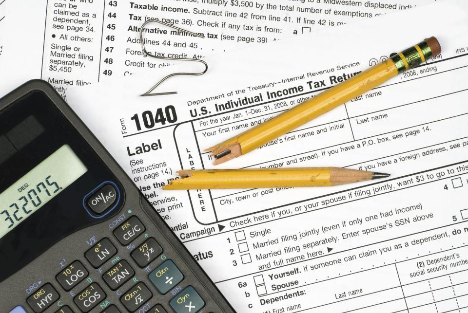 A tax form, calculator, broken pencil and bent paper clip show the frustration of filing taxes.