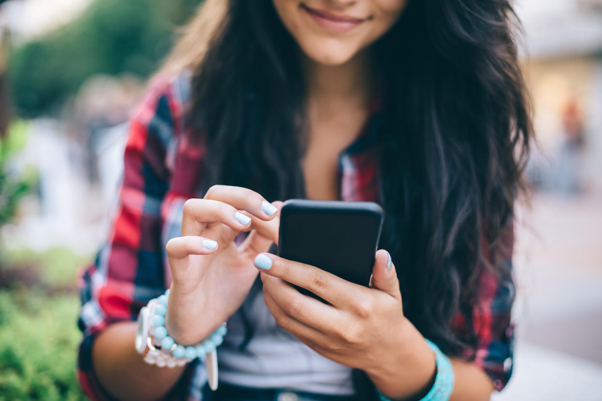 Teenage girl using smartphone at the street