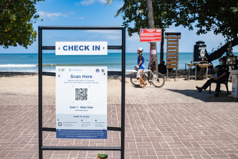  A sign recommends the use of PeduliLindungi App at the beach entrance in Kuta, Bali. Source: EPA
