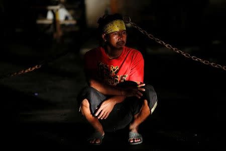 An onlooker follows investigation at the scene where a man was killed by unknown gunmen in Manila, Philippines early October 24, 2016. REUTERS/Damir Sagolj