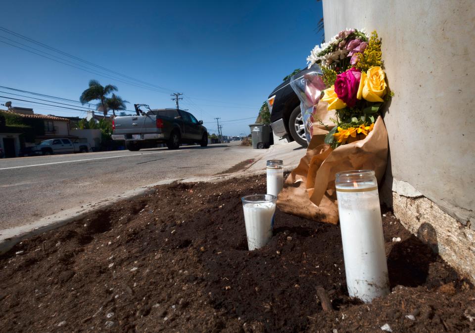 Candles and flowers are placed along along the Pacific Coast Highway in the days after an October crash that killed four college students and injured two others in Malibu, Calif.