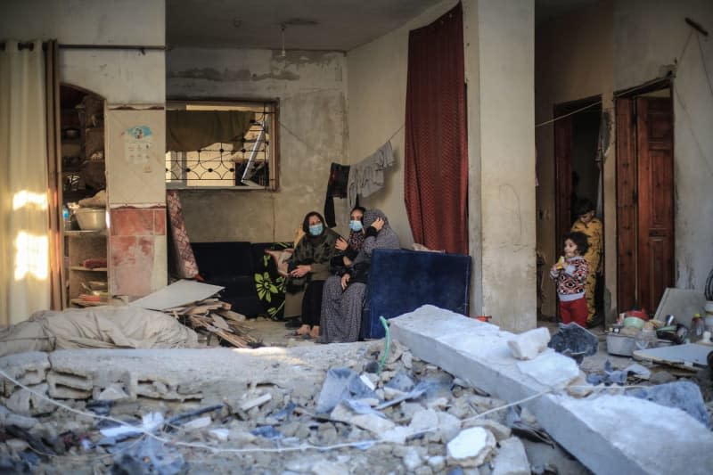 People inspect a damaged building after an Israeli raid on Rafah in the southern Gaza Strip as battles continue between Israel and the Palestinian Hamas movement. Mohammed Talatene/dpa