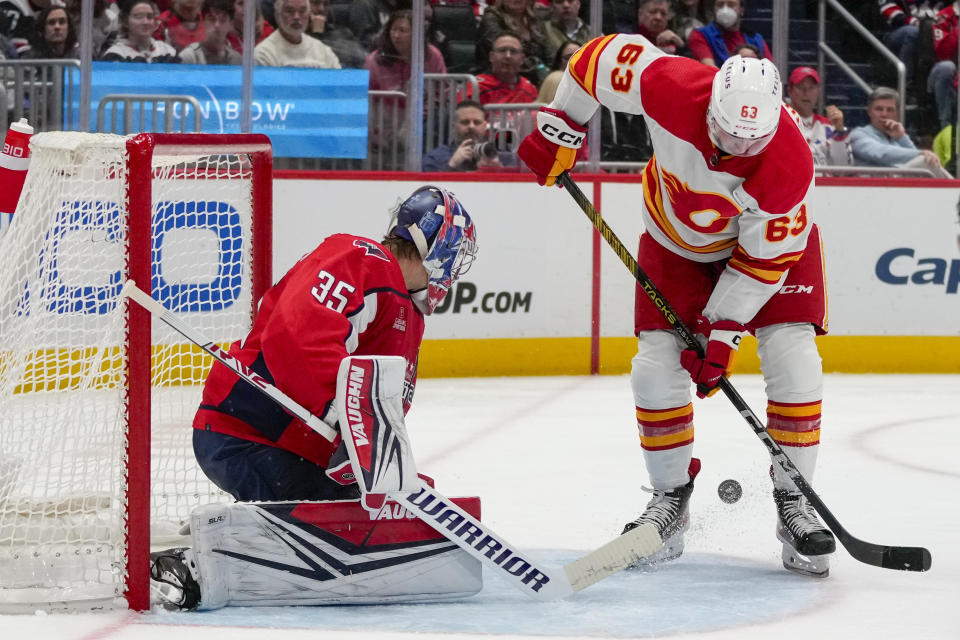 Washington Capitals goaltender Darcy Kuemper (35) deflects the puck past Calgary Flames center Adam Ruzicka (63) in the second period of an NHL hockey game, Monday, Oct. 16, 2023, in Washington. (AP Photo/Alex Brandon)