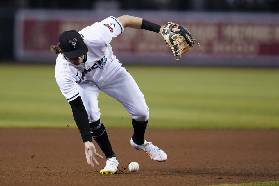 Arizona Diamondbacks shortstop Jake Hager makes a bare-handed grab of a grounder but makes a late throw to first base on a single by San Diego Padres' Jorge Alfaro during the fourth inning of a baseball game Tuesday, June 28, 2022, in Phoenix. (AP Photo/Ross D. Franklin)