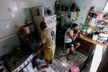 Manoel Pereira Costa (L), known as "Master Manel", prepares coffee next to his son Miquelangelo de Souza Sobrinho Costa at their home in Rio de Janeiro, Brazil, July 26, 2016. REUTERS/Bruno Kelly