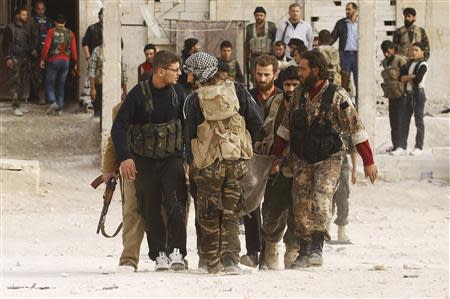 Free Syrian Army fighters carry the body of a fellow fighter who was killed by what the FSA said was during clashes with forces loyal to Syria's President Bashar al-Assad near Base 80 near Aleppo International airport, November 8, 2013. REUTERS/Molhem Barakat