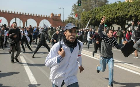 Protesting teachers run from security forces attempting to disperse a demonstration in Rabat, Morocco - Credit: AP