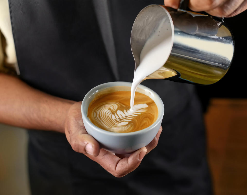 Barista making a cup of coffee latte art