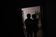 Aygul (R), an ethnic Uighur, and her ethnic Han husband Xiaohe stand in the doorway to their apartment in Beijing, May 19, 2015