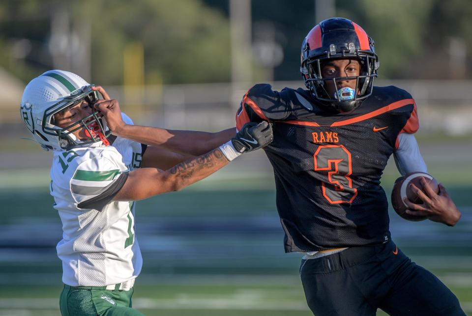 Manual quarterback Amare Breedlove fends off Richwoods’ defender Amari Johnson in the first half of their Week 2 football game Friday, Sept. 6, 2024 at Peoria Stadium. The Rams fell to the Knights 15-6.