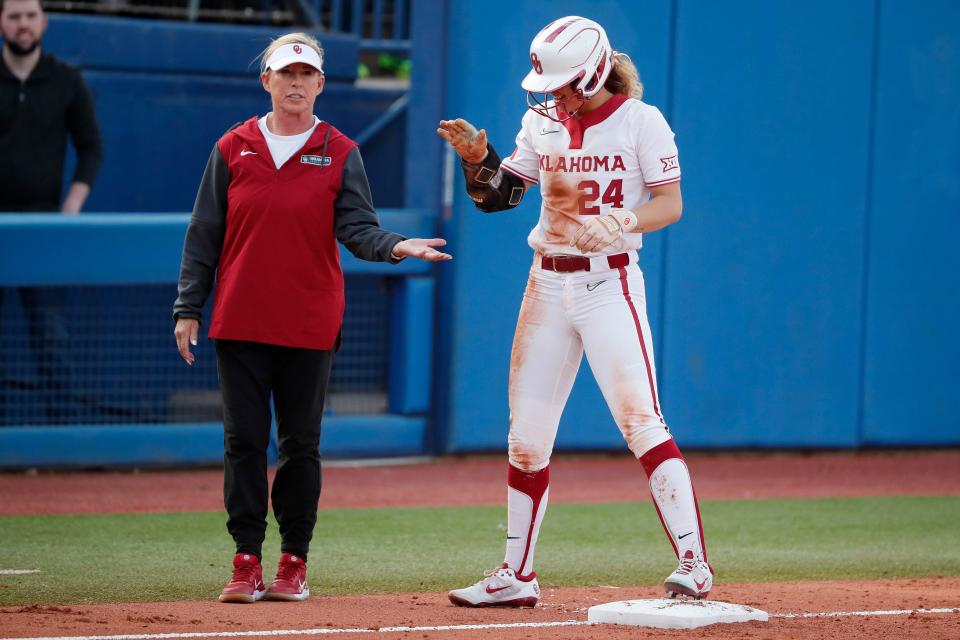 Oklahoma's Jayda Coleman celebrates with coach Patty Gasso at third base in the first inning of a college softball game between the University of Oklahoma Sooners (OU) and the Texas Longhorns at USA Hall of Fame Stadium in Oklahoma City, Friday, March 31, 2023.