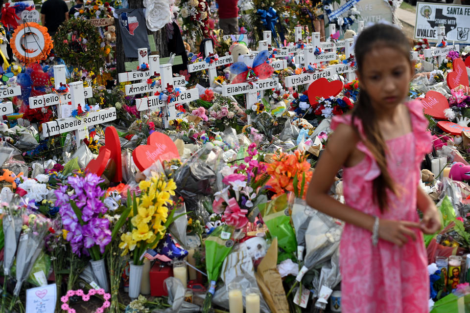 Una niña se para junto a las cruces que se exhiben en el monumento fuera de la Escuela Primaria Robb el 31 de mayo de 2022 en Uvalde, Texas. Salvador Rolando Ramos, un residente de Uvalde de 18 años, disparó y mató a 19 estudiantes y dos maestros en esa escuela. (Foto: Joshua Lott/The Washington Post vía Getty Images)