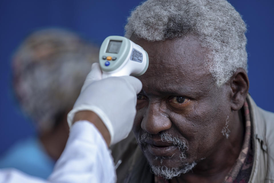 Ethiopians have their temperature checked for symptoms of the new coronavirus, at the Zewditu Memorial Hospital in the capital Addis Ababa, Ethiopia Wednesday, March 18, 2020. For most people, the new coronavirus causes only mild or moderate symptoms such as fever and cough and the vast majority recover in 2-6 weeks but for some, especially older adults and people with existing health issues, the virus that causes COVID-19 can result in more severe illness, including pneumonia. (AP Photo/Mulugeta Ayene)