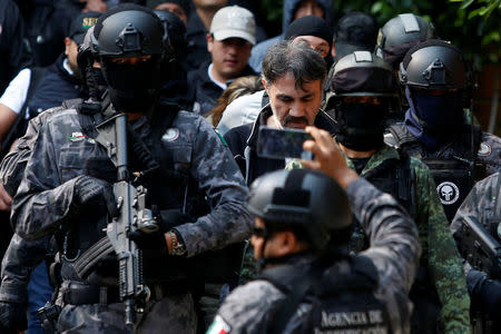 Accused drug kingpin Damaso Lopez (C), nicknamed “The Graduate”, is escorted by police officers in Mexico City, Mexico May 2, 2017. REUTERS/Carlos Jasso