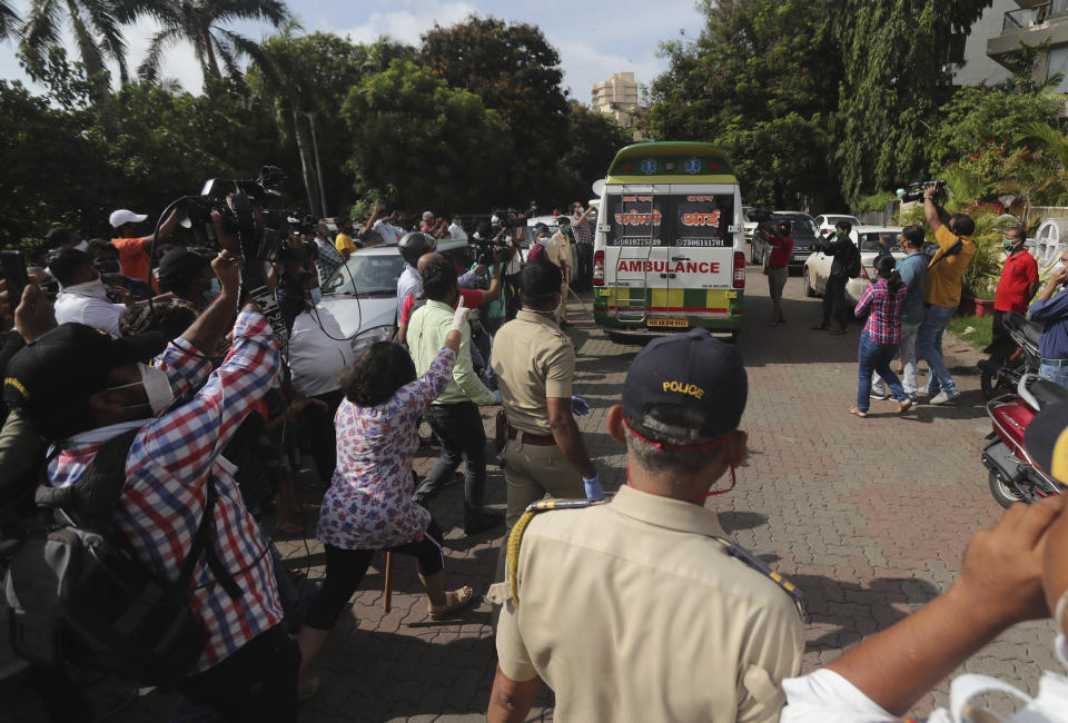 A journalist films as an carrying the body of Bollywood actor Sushant Singh Rajput leaves from the building he lived in Mumbai, India, Sunday, June 14, 2020. Rajput was found dead at his Mumbai residence on Sunday, police and Indian media reports said. (AP Photo/Rafiq Maqbool)