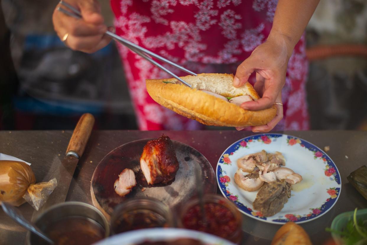 woman preparing street food Banh Mi in Saigon, Vietnam