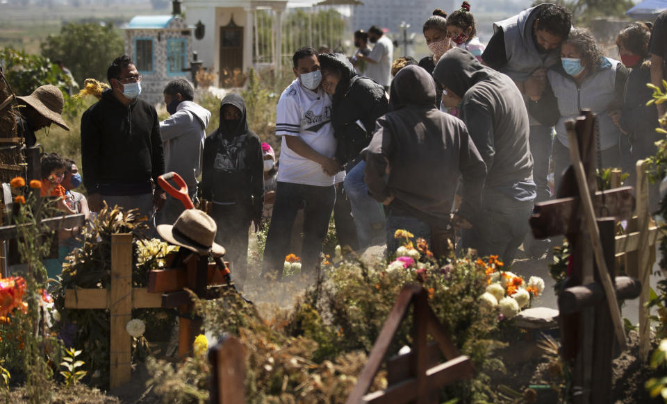 Relatives bury Isaac Nolasc,o who died of reasons not believed related to COVID-19, in a section of the municipal cemetery of Valle de Chalco amid the new coronavirus pandemic, on the outskirts of Mexico City, Sunday, Oct. 25, 2020. Mexican families traditionally flock to local cemeteries to honor their dead relatives as part of the "Dia de los Muertos," or Day of the Dead celebrations, but according to authorities, the cemeteries will be closed this year to help curb the spread of COVID-19. (AP Photo/Marco Ugarte)