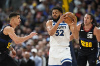 Minnesota Timberwolves center Karl-Anthony Towns, center, collects the ball as Denver Nuggets forwards Michael Porter Jr., left, and Aaron Gordon, right, defend in the first half of Game 2 of an NBA basketball second-round playoff series Monday, May 6, 2024, in Denver. (AP Photo/David Zalubowski)