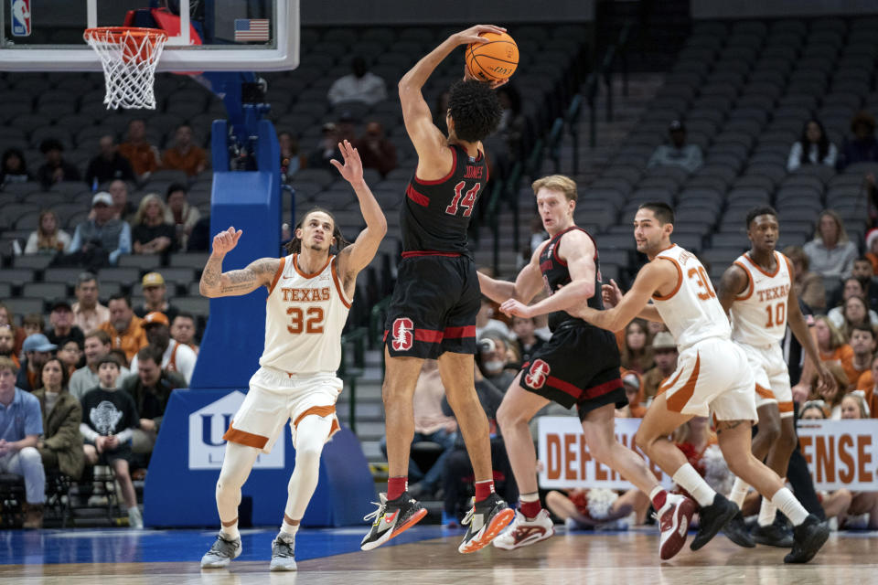 Stanford forward Spencer Jones (14) shoots a 3-pointer over Texas forward Christian Bishop (32) during the first half of an NCAA college basketball game, Sunday, Dec. 18, 2022, in Dallas. (AP Photo/Jeffrey McWhorter)