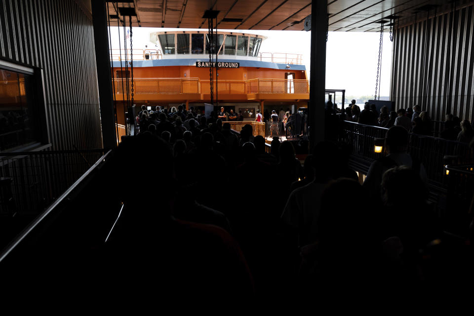 People board the Staten Island Ferry in the Whitehall Terminal, Thursday, Aug. 4, 2022, in New York. (AP Photo/Julia Nikhinson)