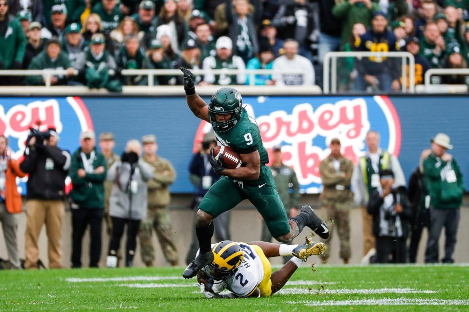 Michigan State running back Kenneth Walker III (9) runs against Michigan defensive back Brad Hawkins (2) during the first half at Spartan Stadium in East Lansing on Saturday, Oct. 30, 2021.